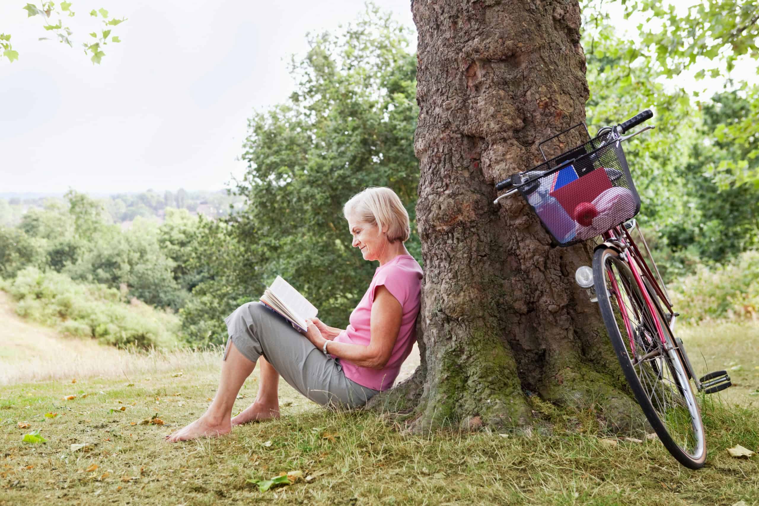 mature woman reading book in park